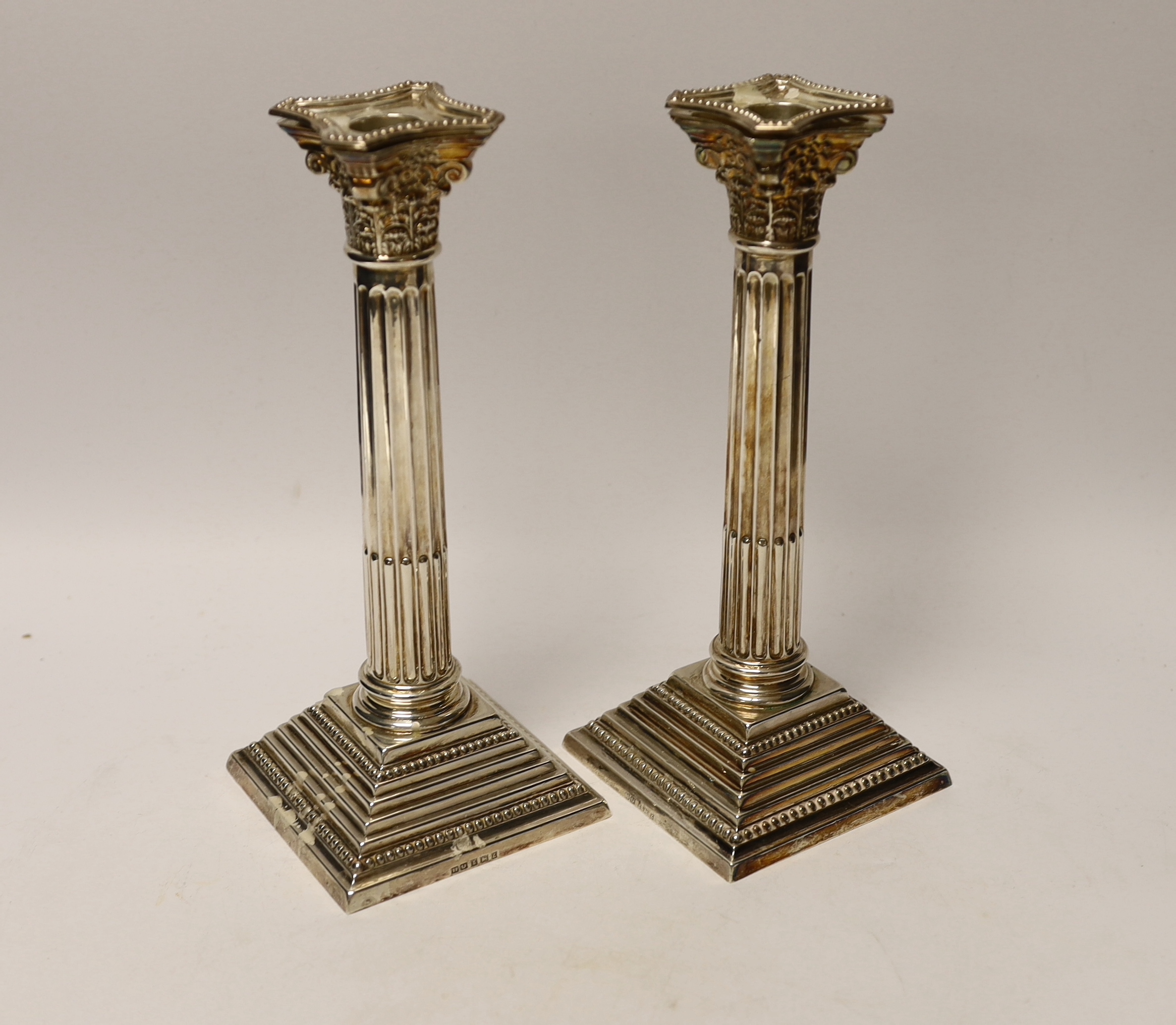 A pair of Elizabeth II silver Corinthian column candlesticks, Hampton Utilities, Birmingham, 1960, 24.3cm, weighted.